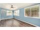 Living Room offers natural light from multiple windows, ceiling fan, and wood laminate flooring at 5865 E Anaheim St, Mesa, AZ 85205