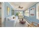 Inviting sunroom with blue walls, ceiling fan and neutral furniture arrangement at 5865 E Anaheim St, Mesa, AZ 85205