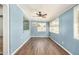 Living Room offers natural light from multiple windows, ceiling fan, and wood laminate flooring at 5865 E Anaheim St, Mesa, AZ 85205