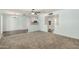 Open-concept living room showing kitchen, blue paint, neutral carpet, and a ceiling fan at 5865 E Anaheim St, Mesa, AZ 85205