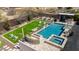Aerial view of backyard featuring pool, spa, outdoor kitchen, and lush artificial turf area at 6328 W Fetlock Trl, Phoenix, AZ 85083