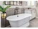 Close up on a modern freestanding tub with sleek fixtures and tiled accent wall at 6328 W Fetlock Trl, Phoenix, AZ 85083