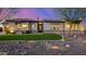 Charming home featuring a manicured front yard, stone accents, and a well-lit exterior enhancing curb appeal at 6328 W Fetlock Trl, Phoenix, AZ 85083