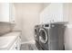 Convenient laundry room with gray front load machines and ample storage space at 6328 W Fetlock Trl, Phoenix, AZ 85083