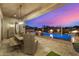 Luxurious outdoor pool area with built-in fire pit and desert views at 6328 W Fetlock Trl, Phoenix, AZ 85083
