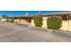 Exterior view of a home with lush bushes, vibrant pink flowers, and an open carport at 711 E Laurel Dr # 17, Casa Grande, AZ 85122