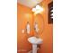 Charming half bathroom with an oval mirror and vibrant orange walls at 7712 S 37Th Way, Phoenix, AZ 85042