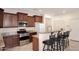 Kitchen with stainless steel appliances, granite countertops, breakfast bar, and dark wood cabinetry at 7712 S 37Th Way, Phoenix, AZ 85042