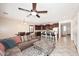 Open-concept living room with a large sectional couch, dining table, and kitchen with a breakfast bar at 7712 S 37Th Way, Phoenix, AZ 85042
