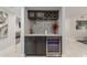Chic bar area boasts a wine refrigerator, custom cabinetry, marble countertop, and modern backsplash at 8618 E Via De Encanto --, Scottsdale, AZ 85258