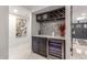 Stylish bar area features a wine refrigerator, custom cabinetry, marble countertop, and decorative backsplash at 8618 E Via De Encanto --, Scottsdale, AZ 85258