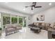 Bright living room with sliding doors to backyard, sleek furniture, ceiling fan, and neutral walls at 8618 E Via De Encanto --, Scottsdale, AZ 85258