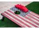 Backyard cornhole game with red beanbags on a rustic American flag-themed board at 8725 E Vista Dr, Scottsdale, AZ 85250