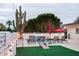 Inviting backyard with a pool, string lights, a manicured lawn, and outdoor seating under a red umbrella at 8725 E Vista Dr, Scottsdale, AZ 85250