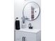Close-up of a bathroom vanity with a round mirror and modern black fixtures at 8725 E Vista Dr, Scottsdale, AZ 85250