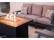 Inviting fire pit table with flames and a comfortable outdoor couch with decorative pillows on a backyard patio at 8725 E Vista Dr, Scottsdale, AZ 85250