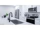 Close up view of kitchen featuring stainless steel appliances, white cabinets, backsplash, and a sink at 8725 E Vista Dr, Scottsdale, AZ 85250