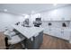Kitchen with stainless appliances, white cabinets, dark hardware, and island with seating at 8725 E Vista Dr, Scottsdale, AZ 85250