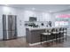 Bright kitchen features stainless steel appliances, white cabinets, dark hardware, and a large island with seating at 8725 E Vista Dr, Scottsdale, AZ 85250
