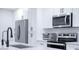 Modern kitchen featuring stainless steel appliances, white cabinets, and a sleek black faucet at 8725 E Vista Dr, Scottsdale, AZ 85250