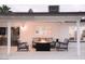 Comfortable outdoor seating area with a fire pit and a white brick house with window and patio roof at 8725 E Vista Dr, Scottsdale, AZ 85250