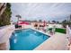Inviting backyard pool with waterfall feature, lounge chairs, barbecue, and outdoor dining, perfect for relaxing and entertaining at 8725 E Vista Dr, Scottsdale, AZ 85250