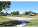 Community basketball court surrounded by lush green spaces and trees, perfect for outdoor recreation at 9512 E Kilarea Ave, Mesa, AZ 85209