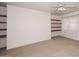 Bedroom with tan carpet, ceiling fan, and a shelf wall design adding modern charm at 9512 E Kilarea Ave, Mesa, AZ 85209