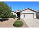 Charming single-story home with a well-maintained yard and a two-car garage, set against a clear blue sky at 9512 E Kilarea Ave, Mesa, AZ 85209