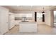 Bright kitchen featuring white cabinets, island with sink, and a window offering natural light at 9512 E Kilarea Ave, Mesa, AZ 85209