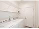 Laundry room with washer, dryer, shelves and a door at 9512 E Kilarea Ave, Mesa, AZ 85209