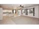 Spacious living area with tile flooring, an open layout connecting to the kitchen, and natural light from the windows at 9512 E Kilarea Ave, Mesa, AZ 85209