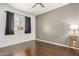 This bedroom offers natural light from the window and has dark curtains and hardwood flooring at 955 E Knox Rd # 224, Chandler, AZ 85225
