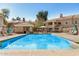 Bright, clear swimming pool surrounded by lounge chairs and well-maintained condo buildings under a sunny blue sky at 955 E Knox Rd # 224, Chandler, AZ 85225
