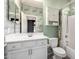 Bathroom featuring vanity, mirror, toilet, shower and green patterned accent wall at 10320 E Tupelo Ave, Mesa, AZ 85212