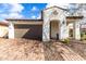 Charming home featuring a brick driveway, two-car garage, and covered front porch, perfect for curb appeal at 10320 E Tupelo Ave, Mesa, AZ 85212