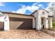 Attractive home with a two-car garage, a covered entrance, and brick accents creating curb appeal at 10320 E Tupelo Ave, Mesa, AZ 85212