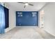 Spacious bedroom with a blue accent wall, ceiling fan, and bathroom view at 10320 E Tupelo Ave, Mesa, AZ 85212