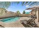 Beautiful backyard area featuring a pool, lounge chairs, and an outdoor patio under shady umbrellas at 1061 E Poncho Ln, San Tan Valley, AZ 85143