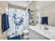 Bright bathroom with a shower-tub combo with a floral curtain, a modern vanity, and a decorative shelf at 1061 E Poncho Ln, San Tan Valley, AZ 85143