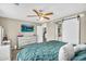 Stylish bedroom with an upholstered bed and decorative pillows, a barn door, and a television mounted on the wall at 1061 E Poncho Ln, San Tan Valley, AZ 85143