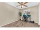 Bedroom featuring neutral paint, a ceiling fan, carpeted floors, and a window illuminating a home office space at 1061 E Poncho Ln, San Tan Valley, AZ 85143