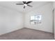 This bedroom has a ceiling fan, carpet, and a large window that brings in lots of light at 1061 S Palo Verde St, Mesa, AZ 85208