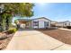 Exterior view of a white home with covered parking, featuring a well-kept yard and long driveway at 1061 S Palo Verde St, Mesa, AZ 85208