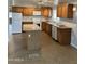 Well-lit kitchen featuring ample wood cabinets, an island, and a full set of white appliances at 10955 N 79Th N Ave # 34, Peoria, AZ 85345