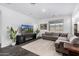 Cozy living room with a comfortable sectional sofa, fireplace, mounted TV, and natural light at 11366 W Ashby Dr, Peoria, AZ 85383