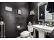 Stylish powder room with modern fixtures and dark accents at 11366 W Ashby Dr, Peoria, AZ 85383