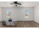 Bright bedroom with wood-look flooring, ceiling fan, and dual windows with neighborhood views at 11474 N 79Th Dr, Peoria, AZ 85345