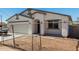 Charming home with a white exterior, desert landscaping, and a two-car garage behind a chain-link fence at 11474 N 79Th Dr, Peoria, AZ 85345