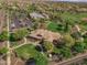 Aerial view of home with well-manicured lawn and garden, and community center complete with parking and pool at 15480 W Corrine Dr, Surprise, AZ 85379